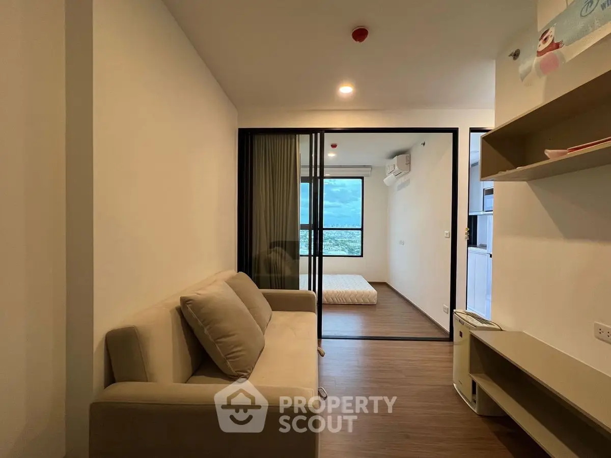 Modern apartment interior with cozy living room and bedroom, featuring large window with scenic view.