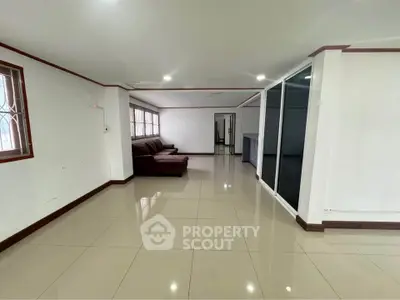 Spacious living room with modern tiled flooring and comfortable seating area.