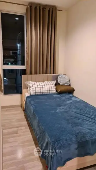 Cozy bedroom with modern decor and large window for natural light.