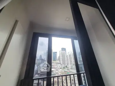 Stunning city view from a modern apartment balcony with large windows.