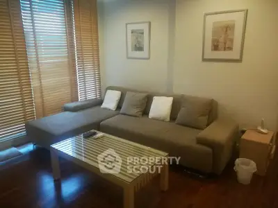 Cozy living room with modern sofa and glass coffee table, perfect for relaxation.