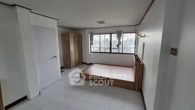 Spacious bedroom with minimalist design and large windows for natural light.