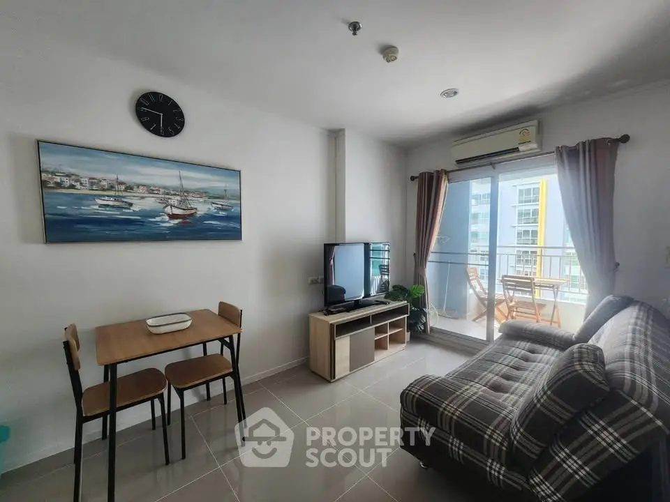 Modern living room with balcony access, featuring stylish furniture and natural light.