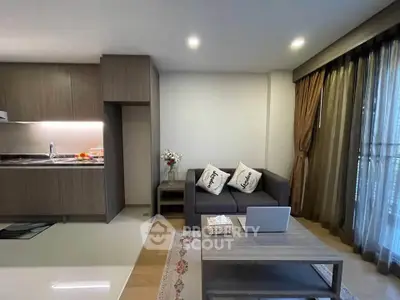 Modern living room with open kitchen, cozy sofa, and elegant decor in a stylish apartment.