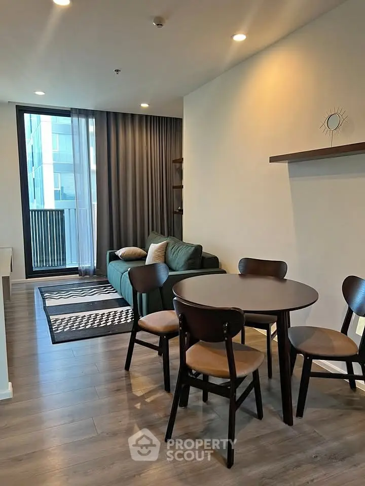 Modern living room with stylish furniture and large window offering natural light.