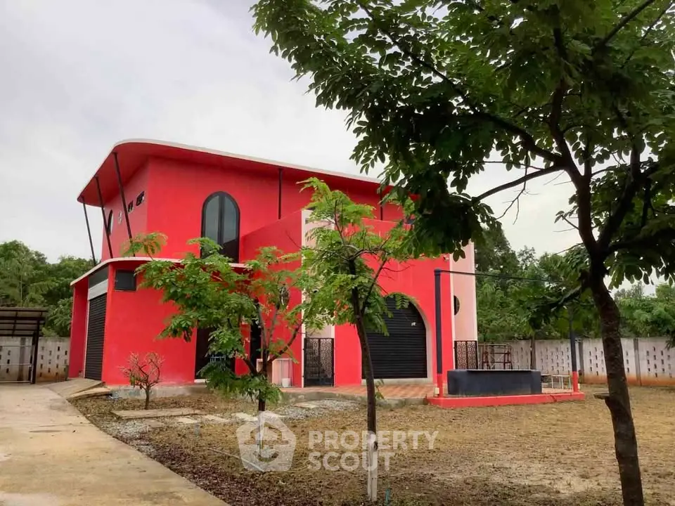 Stunning modern red house with unique architecture and lush greenery