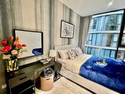 Luxurious bedroom with modern decor and large window offering stunning city views.