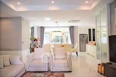 Luxurious open-plan living room with elegant dining area and modern kitchen, featuring plush seating and stylish decor.