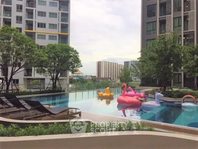 Luxurious apartment complex with inviting pool and playful inflatables, perfect for relaxation and leisure.