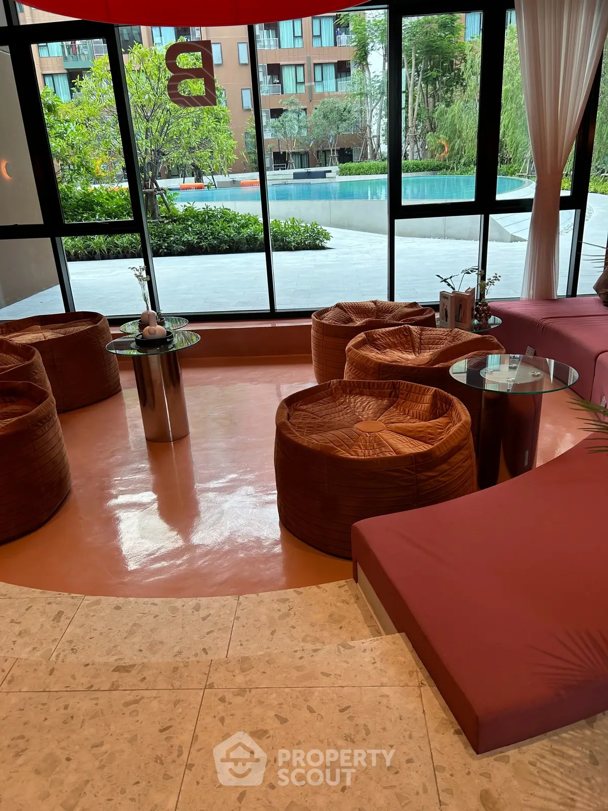 Luxurious modern lounge with stylish seating and pool view, perfect for relaxation and social gatherings.