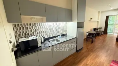 Modern kitchen with sleek cabinetry and appliances in a cozy apartment setting.