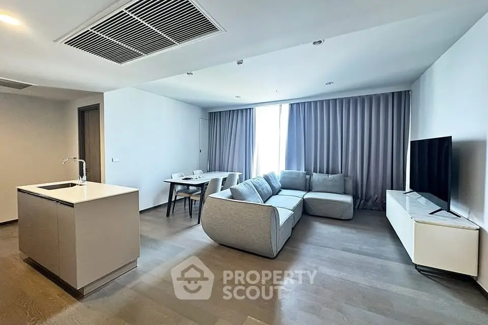 Modern living room with sleek furniture and open kitchen layout, perfect for contemporary living.
