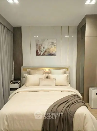Luxurious bedroom with elegant decor and cozy bedding in modern apartment.