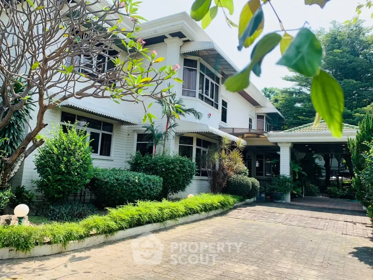 Charming two-story house with lush garden and spacious driveway, perfect for family living.