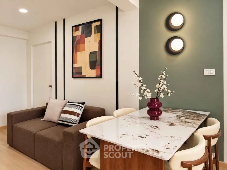 Modern living room with stylish decor and elegant dining area, featuring a cozy sofa and chic wall art.