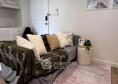 Cozy living room with stylish sofa and decorative pillows, perfect for relaxation.