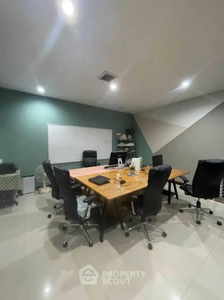 Modern study room with large wooden table and office chairs, ideal for meetings.