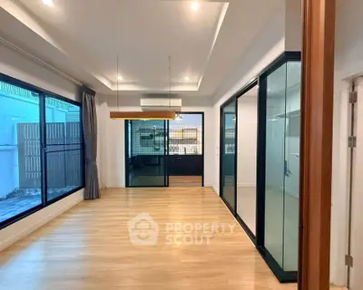 Spacious modern living room with large windows and wooden flooring