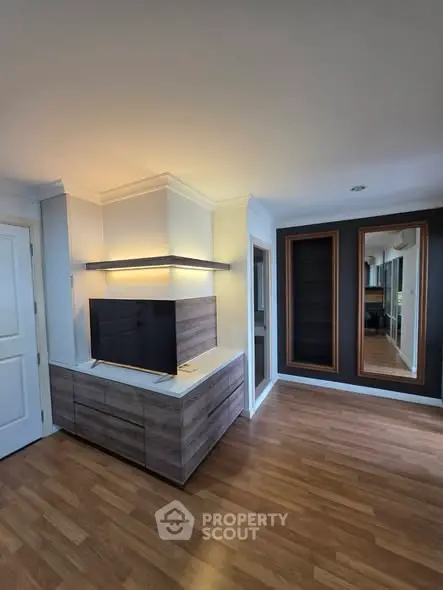 Modern living room with sleek TV unit and wooden flooring