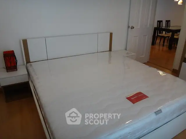 Spacious bedroom with modern furniture and hardwood flooring