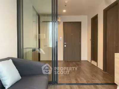 Modern apartment entrance with sliding glass doors and cozy seating area.