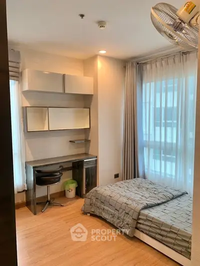 Cozy bedroom with modern decor, featuring a sleek desk and comfortable bed, perfect for a serene living space.