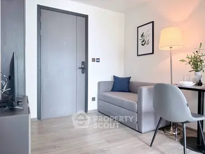 Modern living room with sleek gray sofa, stylish decor, and cozy lighting in a contemporary apartment.