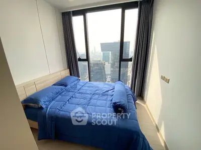 Modern bedroom with floor-to-ceiling windows offering stunning city views.