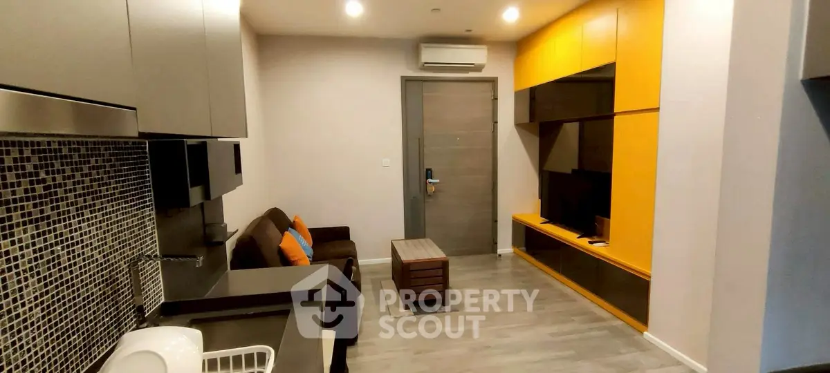 Modern living room with stylish yellow cabinetry and cozy seating area.