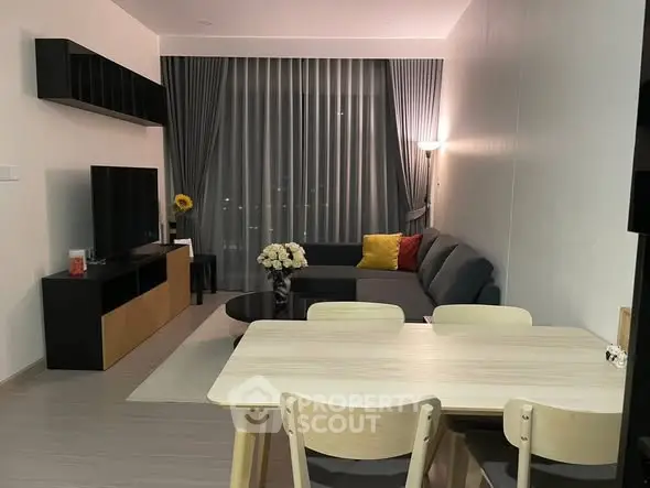 Modern living room with stylish furniture and large window, perfect for cozy evenings.