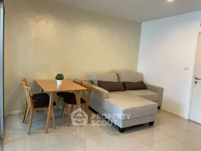 Modern living room with cozy sofa and dining table, perfect for relaxation and entertaining.
