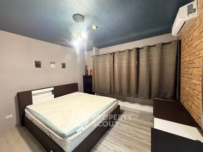 Spacious modern bedroom with stylish decor and air conditioning, perfect for comfort and relaxation.