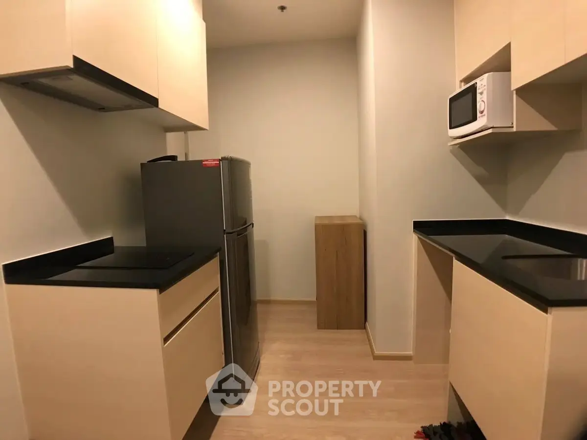 Modern kitchen with sleek black countertops and compact layout