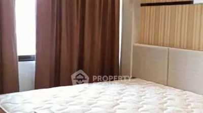 Cozy bedroom with plush mattress and elegant curtains, perfect for restful nights.