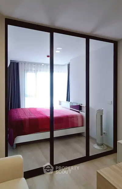 Modern bedroom with large mirrored wardrobe and stylish decor