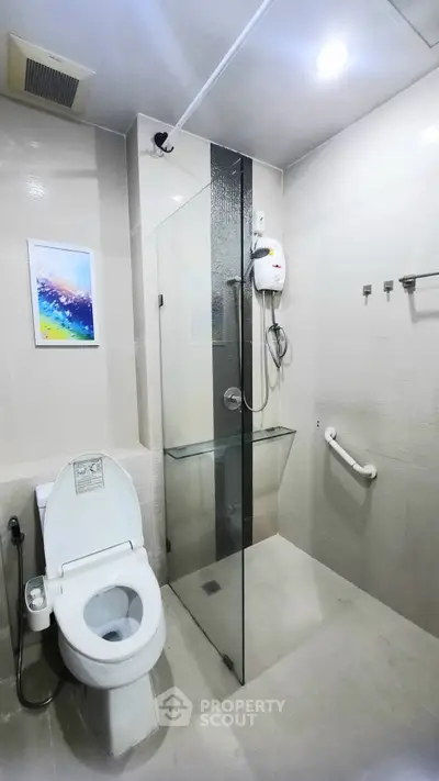 Modern bathroom with glass shower and sleek fixtures in a contemporary home.