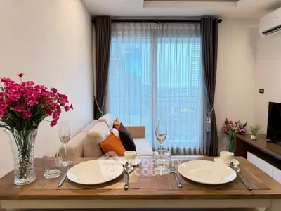 Modern living room with elegant dining setup and large window view.