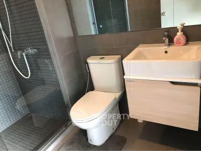 Modern bathroom with sleek shower and stylish vanity in contemporary apartment.