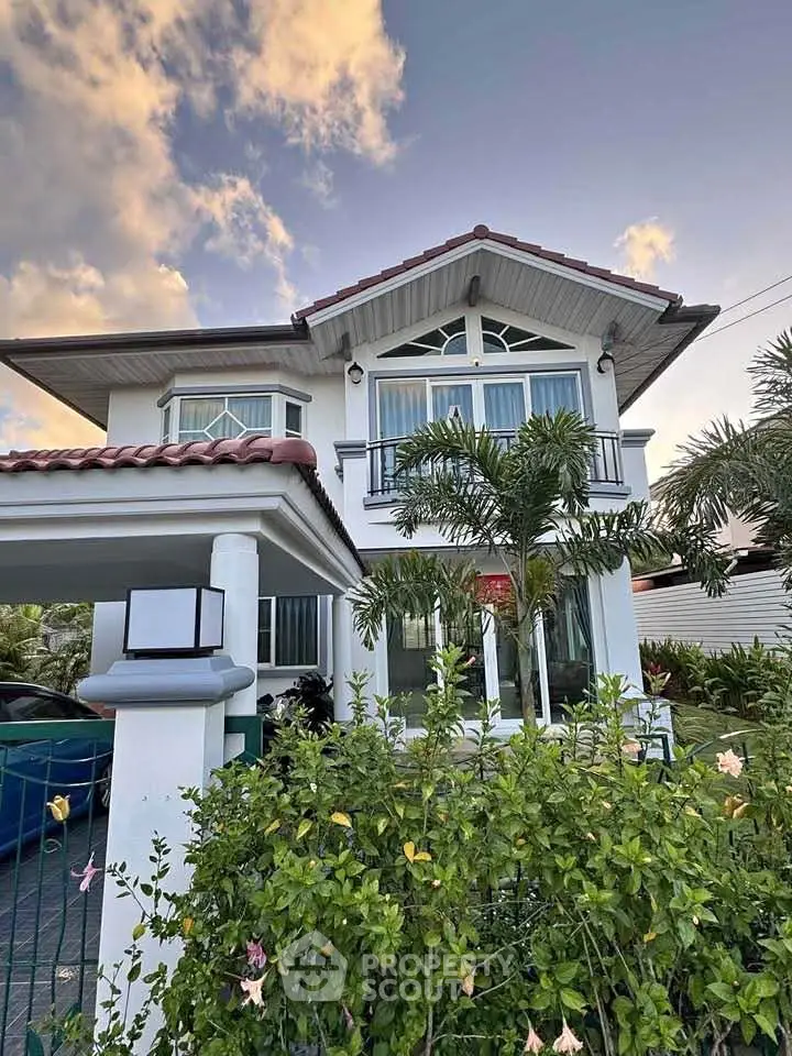 Charming two-story house with lush garden and modern architecture.