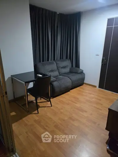 Cozy living room with modern sofa and wooden flooring, perfect for relaxation and comfort.