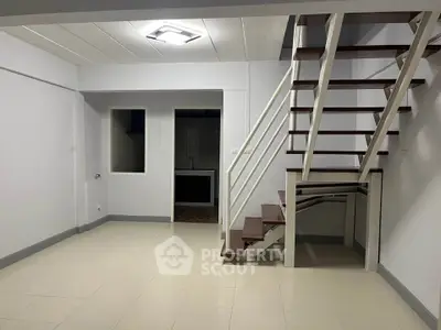 Spacious modern living room with staircase and open layout, ideal for contemporary living.