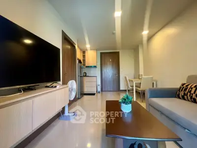 Modern living room with sleek furniture and open kitchen layout in a stylish apartment.