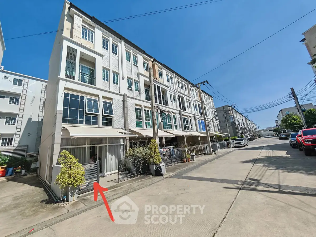 Modern townhouse with spacious facade and large windows in a sunny neighborhood.