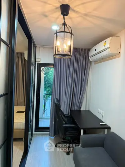 Modern study room with desk, chair, and air conditioning, featuring a view of the balcony through glass doors.