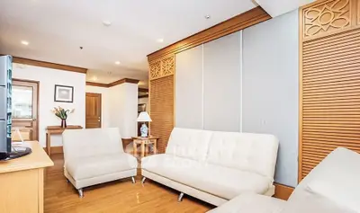 Spacious living room with modern white sofas and elegant wooden accents