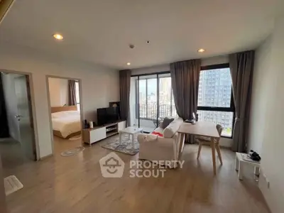 Spacious modern living room with city view, featuring cozy seating and elegant decor.