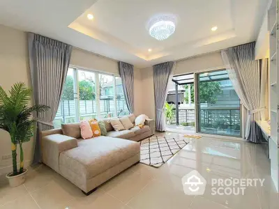 Spacious living room with modern decor and large windows opening to a garden view.