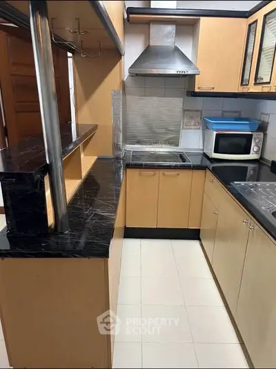 Modern kitchen with sleek black countertops and wooden cabinets