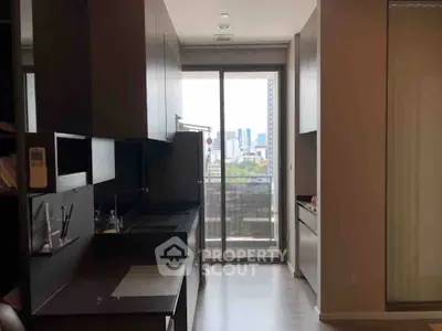 Modern kitchen with sleek cabinetry and city view from balcony