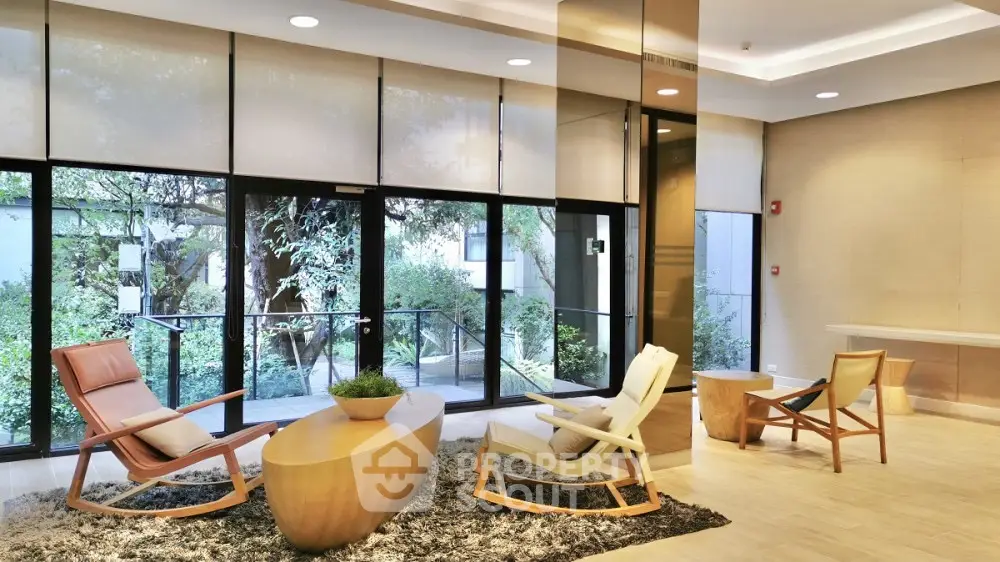 Luxurious modern lobby with stylish seating and large windows overlooking lush greenery.
